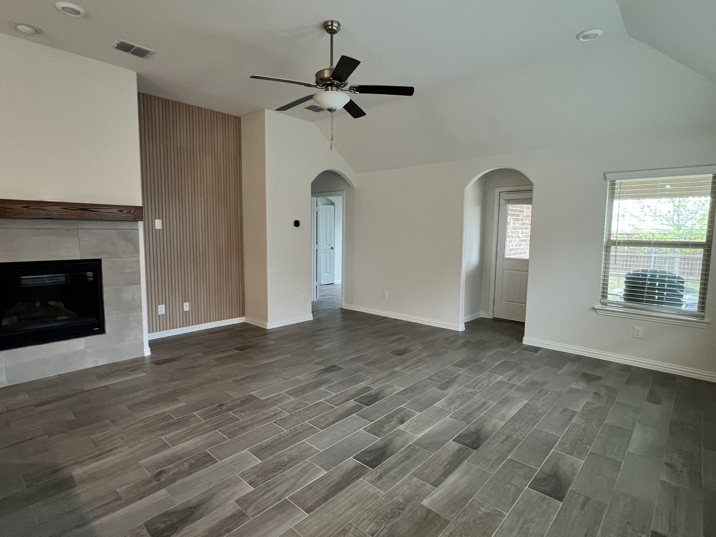 Open-plan living area finished by BSB Remodeling with wood-look tile flooring