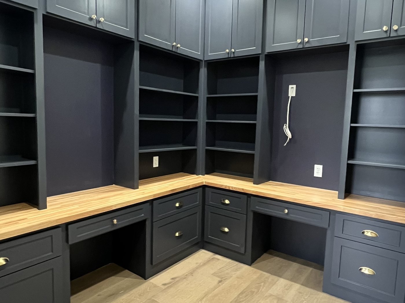 Custom navy built-in shelving and desk with a butcher-block work surface