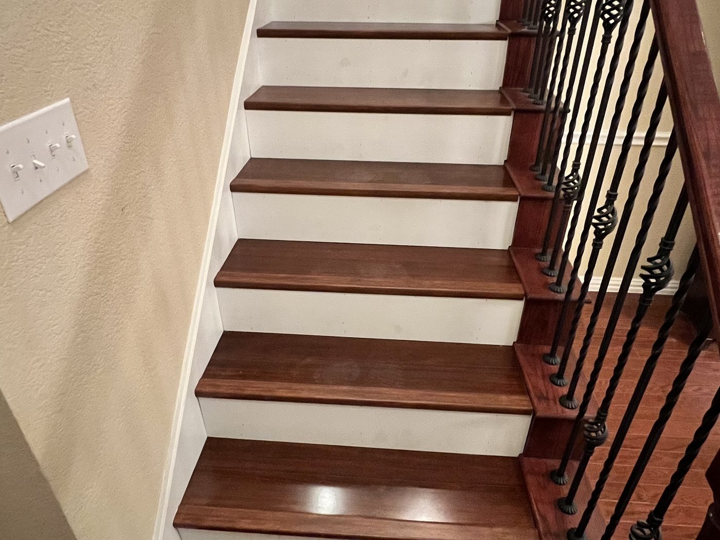 Refinished staircase with dark stained treads, white risers and iron balusters