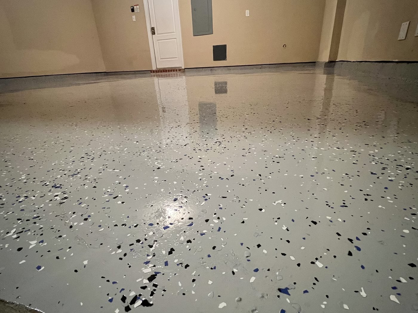 Garage floor finished in gray flake epoxy with a high-gloss coating